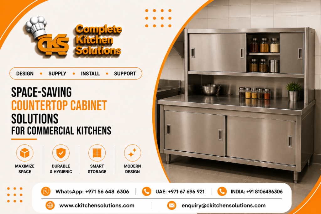 A promotional banner for "Complete Kitchen Solutions" titled "Space-Saving Countertop Cabinet Solutions for Commercial Kitchens," featuring custom stainless steel kitchen storage furniture, including a heavy-duty worktable with a lower sliding-door cabinet and an integrated upper countertop hutch with sliding doors and spice organizers.