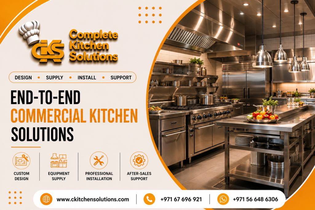 A promotional banner for "Complete Kitchen Solutions" titled "End-to-End Commercial Kitchen Solutions," featuring a high-end, fully equipped stainless steel commercial kitchen with a cooking line, extraction hoods, hanging pendant heat lamps, and a central preparation island table.