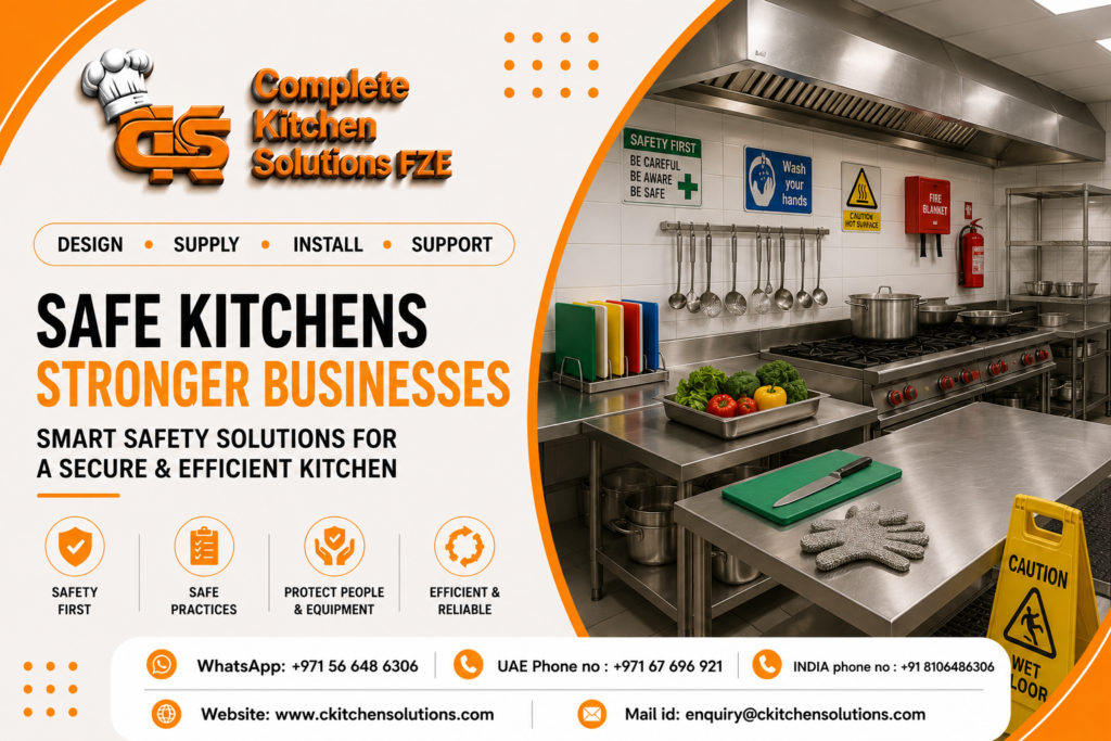 A commercial stainless steel kitchen prep station displaying safety signage, a fire extinguisher, color-coded cutting boards, heat-resistant gloves, and a wet floor sign, branded by Complete Kitchen Solutions FZE.